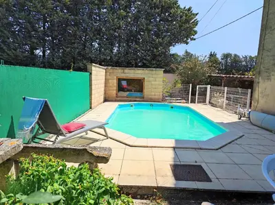 a swimming pool with a chair and a chair sidx sidx sidx at Chambre de 2 personnes dans Mas de Lubéron in Robion en Luberon