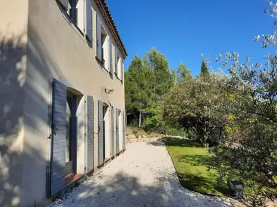 an external view of a building with doors and trees at Maison de vacances avec piscine privative, Oustau des Oliviers vue dominante Colorado provençal in Rustrel