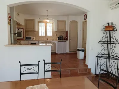 a kitchen with a table and chairs in a room at Maison de vacances avec piscine privative, Oustau des Oliviers vue dominante Colorado provençal in Rustrel