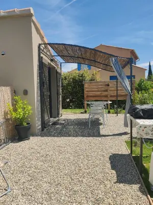 a patio with a wooden pergola next to a house at Gite l'épinette in Saint-Saturnin-les-Apt
