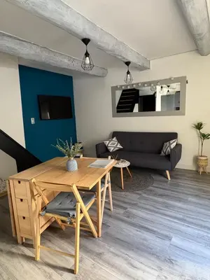 a living room with a table and a couch at Le Nid Provençal in Lambesc