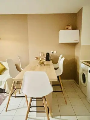 a kitchen with a table with white chairs and a microwave at T3 Panoramique Centre Aix en Provence in Aix-en-Provence