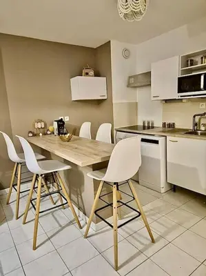 a kitchen with a wooden table and white chairs at T3 Panoramique Centre Aix en Provence in Aix-en-Provence