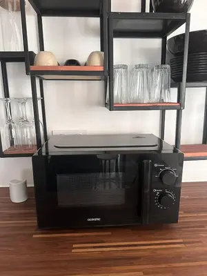 a black microwave oven sitting on top of a table at Bel appartement en plein cœur de Carpentras in Carpentras