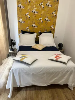 a bedroom with a large bed with a yellow headboard at Bel appartement en plein cœur de Carpentras in Carpentras