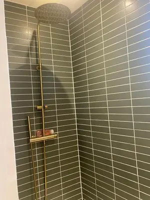 a shower in a bathroom with blue tiles at Bel appartement en plein cœur de Carpentras in Carpentras
