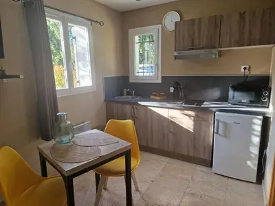 a kitchen with a table and yellow chairs and a white refrigerator at le mazet de LOÏS in Carpentras