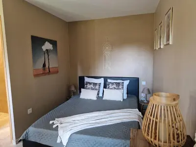 a bedroom with a bed with blue sheets and white pillows at le mazet de LOÏS in Carpentras