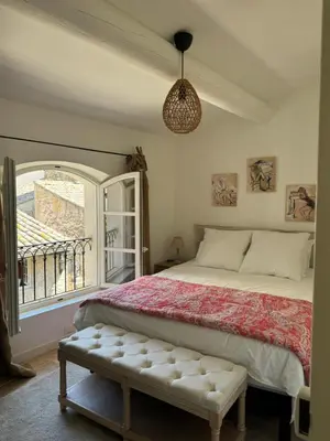 a bedroom with a bed and a large window at La bohème in Lourmarin
