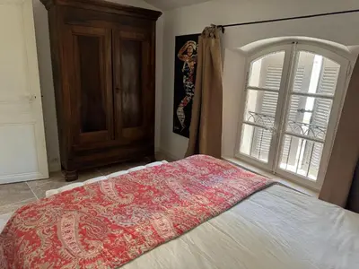 a bedroom with a bed and a window at La bohème in Lourmarin