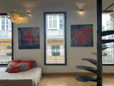 a bedroom with two windows and a bed with red pillows at Le Loft du Matheron in Aix-en-Provence