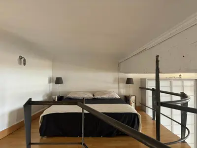 a bedroom with a bed in a white room at Le Loft du Matheron in Aix-en-Provence