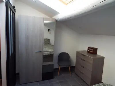 a room with a chair and a cabinet and a bedroom at Valentins cottage Moulin de Tartay Avignon in Avignon