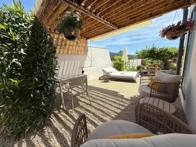 a patio with chairs and a table and a couch at Une nuit en Luberon et SPA in Puyvert