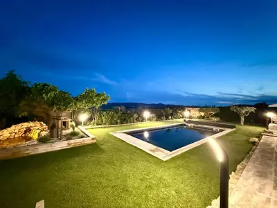 a backyard with a swimming pool at night at Une nuit en Luberon et SPA in Puyvert