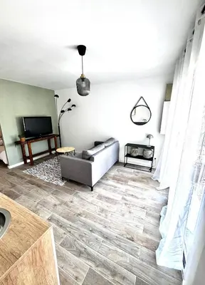 a living room with a couch and a television at Charmant T2 atypique proche du centre-ville in Miramas