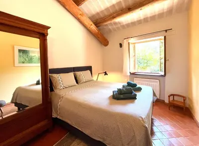a bedroom with a bed and a window at Le Chant des Bories in Gordes