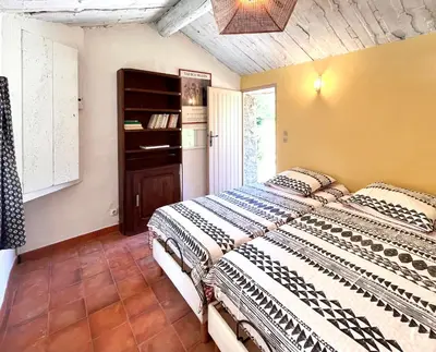 a bedroom with two beds and a window at Le Chant des Bories in Gordes