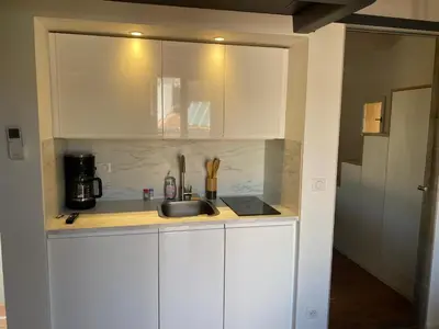 a kitchen with white cabinets and a sink at Studio centre historique Aix en Provence in Aix-en-Provence