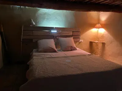 a bedroom with a bed with a light on it at Charmante Maison au cœur du village in Rustrel