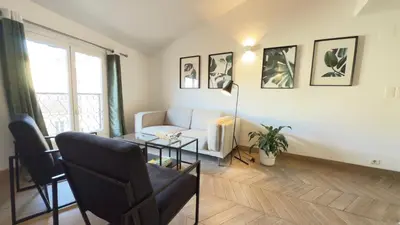 a living room with a couch and a table at Appartement climatisé 2 chambres Centre historique in Aix-en-Provence
