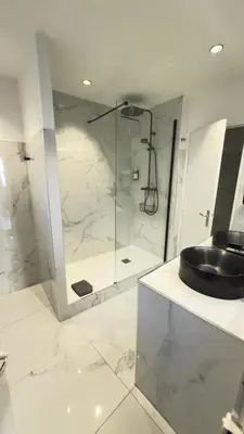 a bathroom with a glass shower and a sink at Appartement climatisé 2 chambres Centre historique in Aix-en-Provence