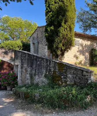 a stone wall in front of a house at Bergerie in Montjustin