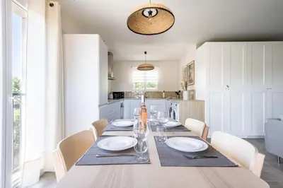 a dining room with a table with white plates and chairs at Tropiques en Provence in Morières-lès-Avignon
