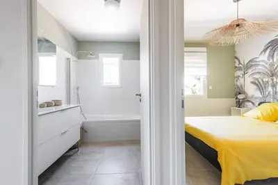 a bedroom with a yellow bed and a bath tub at Tropiques en Provence in Morières-lès-Avignon