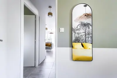 a living room with a mirror and a yellow couch at Tropiques en Provence in Morières-lès-Avignon