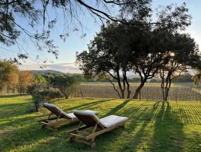 two lounge chairs sitting in the grass with a fence at Domaine Camp Fourca in Mirabeau