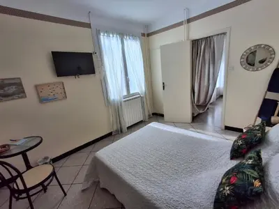 a bedroom with a bed and a table and a tv at Chambre à louer à la nuitée in Sénas