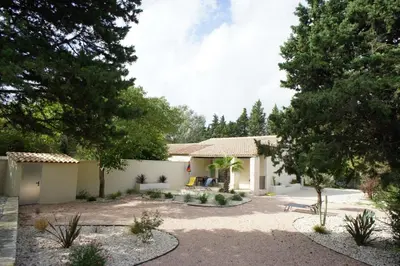 a house with a yard with trees in front of it at Maison avec piscine et jacuzzi proche de la rivière idéale pour un séjour détente in Le Thor
