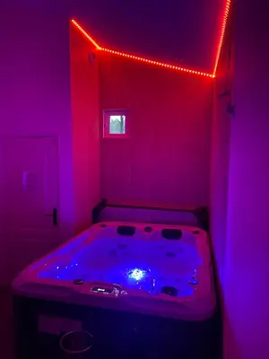 a hot tub in a room with purple lights at Maison avec piscine et jacuzzi proche de la rivière idéale pour un séjour détente in Le Thor