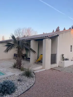 a house with a palm tree in front of it at Maison avec piscine et jacuzzi proche de la rivière idéale pour un séjour détente in Le Thor