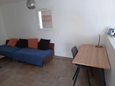 a living room with a blue couch and a wooden table at Villa proche d'Avignon in Jonquerettes