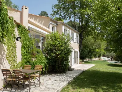 a patio with a table and chairs and an umbrella at Villa Hélène in Aix-en-Provence
