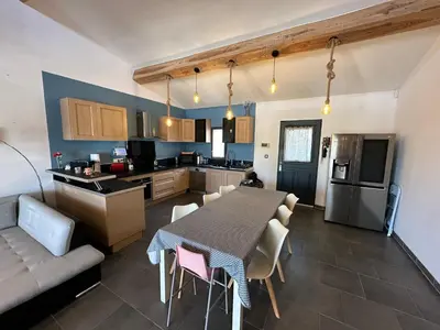 a kitchen and living room with a table and a couch at Maison Isle sur la sorgue in LʼIsle-sur-la-Sorgue