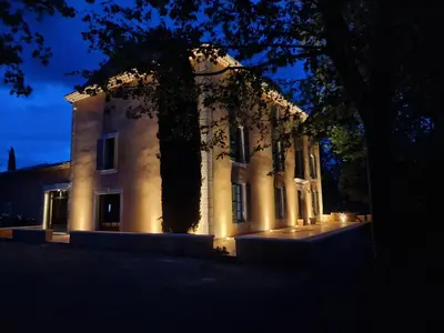 a building with lights in front of it at night at Bastide des 7 Sœurs in Roussillon