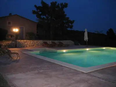 a swimming pool in a yard at night at La maison Danna in Lauris