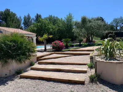 a garden with wooden steps and flowers and trees at Studio le soleil couchant in Saint-Saturnin-lès-Avignon