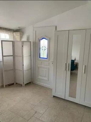 a room with white closets and a window at Studio le soleil couchant in Saint-Saturnin-lès-Avignon