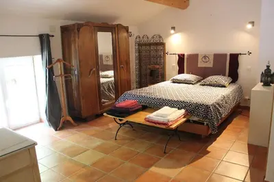 a bedroom with a bed and a table in a room at Mas Aubert in Eyragues