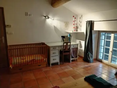 a bedroom with a desk and a crib in a room at Mas Aubert in Eyragues