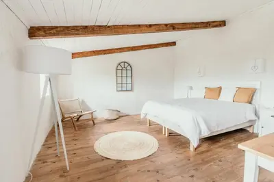 a white bedroom with a bed and a table at Le Bas Château Provence Luberon in Saint-Michel-lʼObservatoire