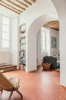 a living room with a couch and a book shelf at Le Bas Château Provence Luberon in Saint-Michel-lʼObservatoire