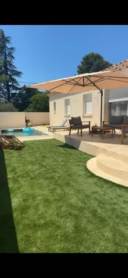 a patio with picnic tables and a green lawn at Villa Zen in Entraigues-sur-la-Sorgue