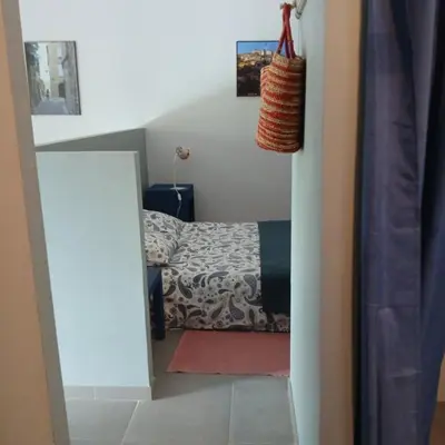 a small bedroom with a bed and a mirror at La cigale bleue in Gordes