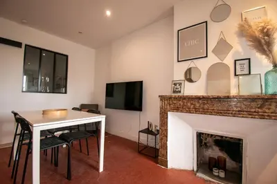 a living room with a table and a fireplace at Cosy et lumineux - hyper centre - wifi in Aix-en-Provence
