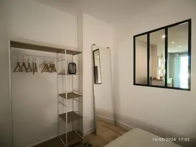 a room with a mirror and a shelf with hangers at Cosy et lumineux - hyper centre - wifi in Aix-en-Provence